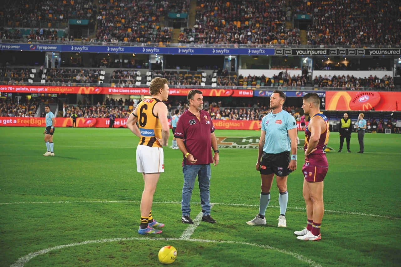 Owner Keith Baines flipping the coin before a Brisbane Lions game, one of a number of organisations that Accurate Road Profiling Services sponsors and supports.